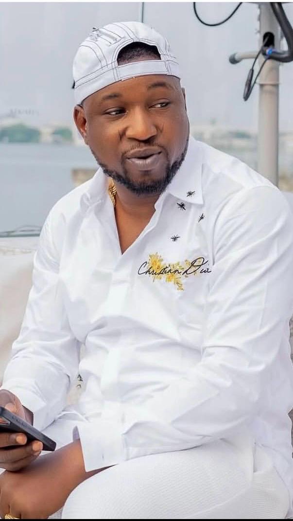 Tunde Perry holding the gold chain thrown by May D during a concert
